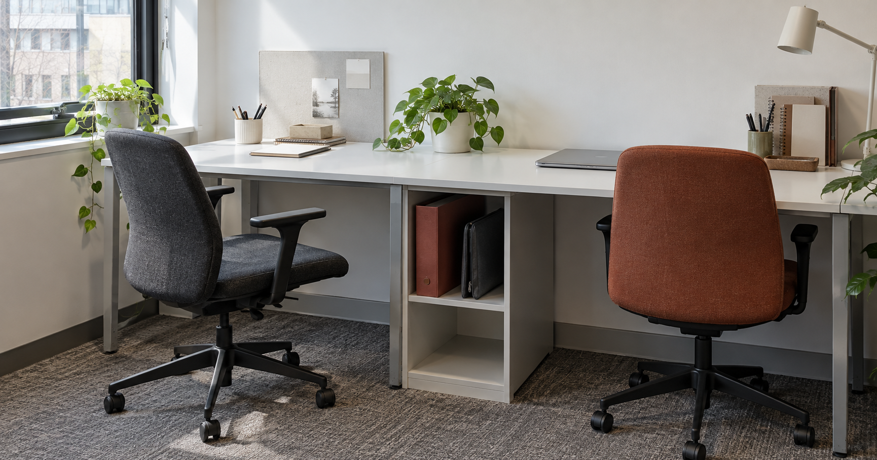 A shared office with two empty chairs and records stored between the desks.